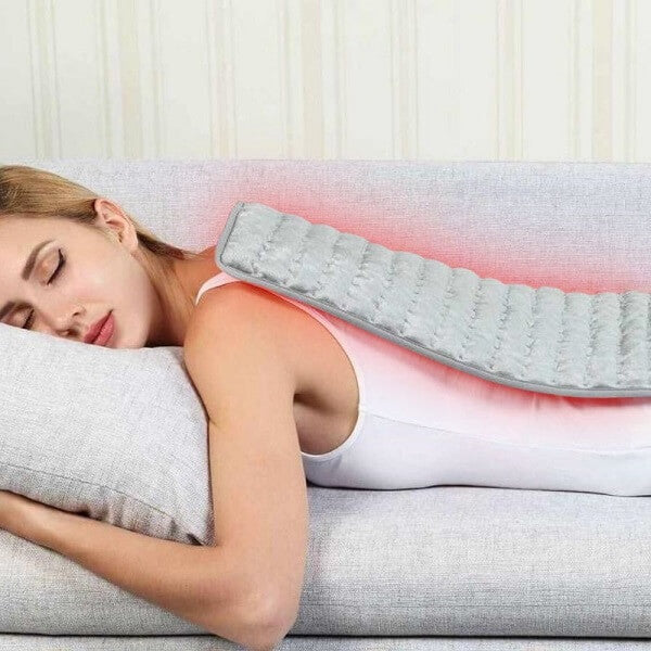 Image of a woman relaxing with ThermaPad on her back.